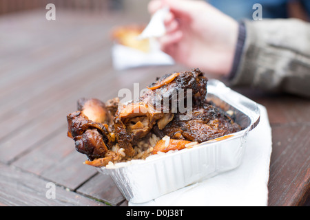 Frau isst einen Take-away Karton gezogen Ruckhuhn in Love Food Fayre in Bemalung, Bristol, England. Stockfoto