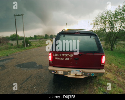 Sturmjäger beobachten einen großen Tornado aus der Sicherheit ihres Fahrzeugs Stockfoto