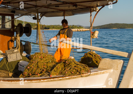 Fischer mit seinem Boot Überprüfung seiner Netze, Vonitsa, Ambrakischen Golf, Griechenland Stockfoto