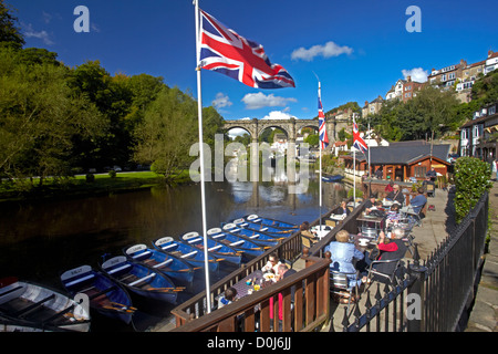 Ein Blick auf den Fluß Nidd im riverside Café mit dem viktorianischen Eisenbahnviadukt spiegelt sich in das Wasser unten. Stockfoto