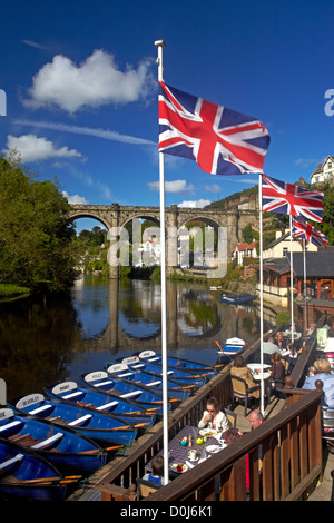 Ein Blick auf den Fluß Nidd im riverside Café mit dem viktorianischen Eisenbahnviadukt spiegelt sich in das Wasser unten. Stockfoto