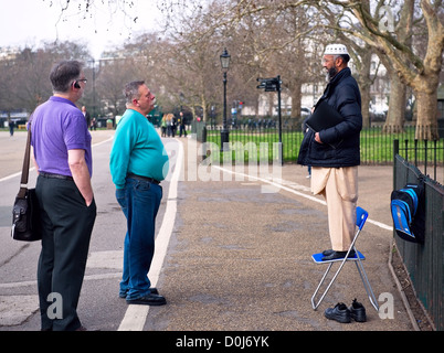 Ein Muslim, im Gespräch mit zwei anderen Männern bei Speakers Corner in London. Stockfoto