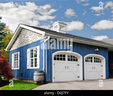 Doppelte Pkw-Garage mit weißen Türen und blau außen Stockfoto