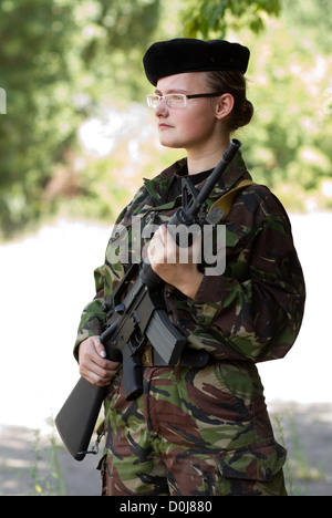 Junges Mädchen mit automatischen Gewehren auf Wache stehen Stockfoto