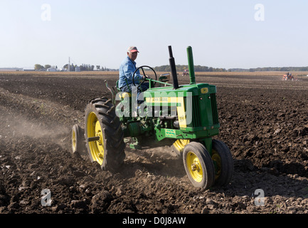 1956 John Deere Modell 520 pflügen ein Feld auf einer Farm in der Nähe von Hebron, Illinois in einem antiken Traktor Pflügen Demonstration. Stockfoto