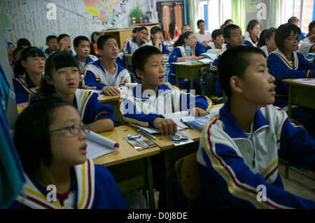 Chinesische Schüler besuchen eine Lektion in einem Klassenzimmer an einer Mittelschule für Wanderarbeiter am Stadtrand von Peking, China. 2012 Stockfoto