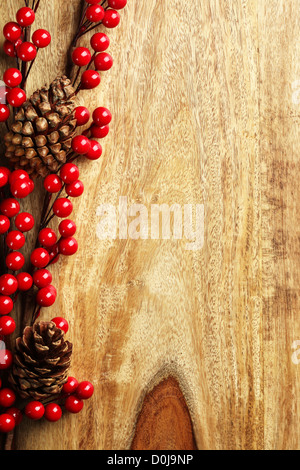 Beeren und Tannenzapfen auf hölzernen Hintergrund Stockfoto