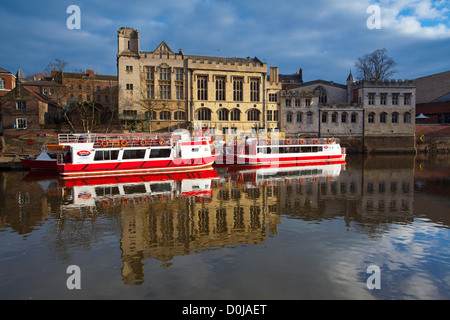 York City Flusskreuzfahrt Boote auf dem Fluss Ouse mit der Zunftsaal im Hintergrund. Stockfoto