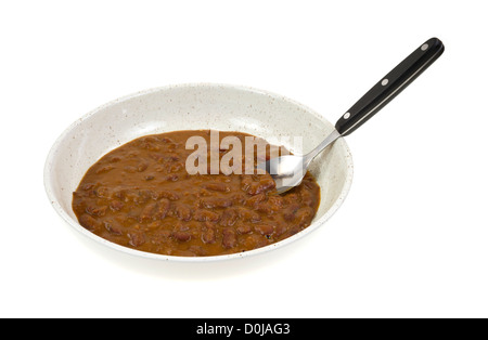 Eine Portion rote Kidney-Bohnen curry in eine kleine Schüssel mit Suppenlöffel auf einem weißen Hintergrund. Stockfoto