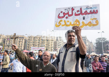 27. November 2012. Demonstranten protestieren gegen Präsident Morsi Annahme der absoluten Mächte auf dem Tahrir-Platz, hält Kairo eine ein Schild in arabischer Sprache, das bedeutet "Die Dinge sind ein totales Durcheinander" ein anderes hält ein Kreuz in Solidarität. Stockfoto