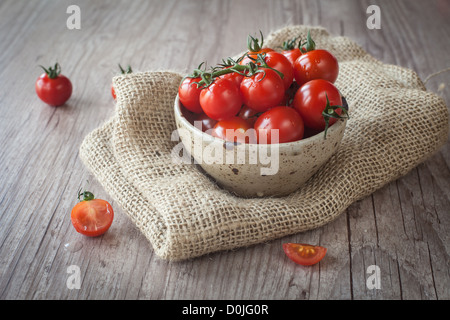 Tasse mit ein paar frischen Tomaten auf einem Holztisch Stockfoto