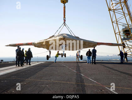 Ein X-47 b Unmanned Combat Aircraft wird auf dem Flugdeck des Flugzeugträgers USS Harry S. Truman 26. November 2012 in Norfolk, Virginia übertragen  Die X-47 b ist die neueste in der UAV-Technologie und der Truman ist der erste Flugzeugträger, Host-Testbetrieb für eine unbemannte Flugzeuge. Stockfoto