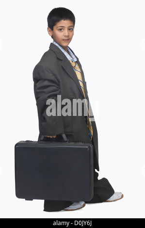 Bildnis eines Knaben tragen übergroße Anzug und Abhaltung Aktentasche Stockfoto