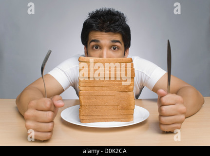 Mann starrte auf die Brotscheiben Stockfoto