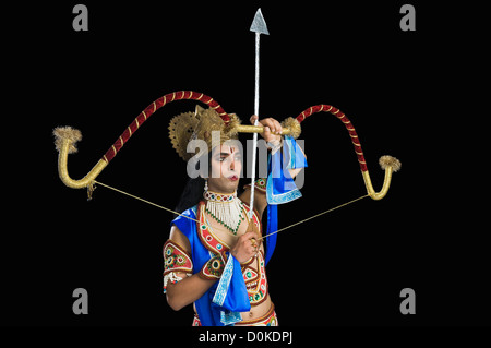 Mann verkleidete als Rama und hält einen Bogen und Pfeil Stockfoto