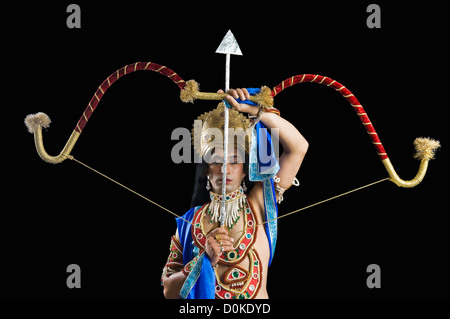 Mann verkleidete als Rama und hält einen Bogen und Pfeil Stockfoto