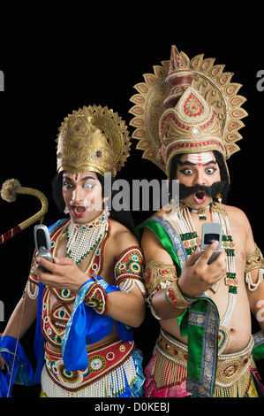 Zwei Männer verkleidete als Rama und Ravana und Lesen von SMS Stockfoto