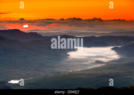 Sonnenaufgang über dem Llynnau Mymbyr und Capel Curig Dorf von Gallt y Wenallt in Snowdonia-Nationalpark. Stockfoto