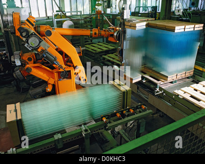 Ein Roboter-Stapel verpackt Leuchtstoffröhren in einer Industriehalle. Stockfoto