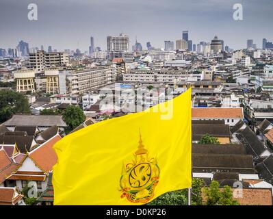 27. November 2012 - Bangkok, Thailand - die Flagge der thailändischen Monarchie über der Stadt von Bangkok von der Spitze des Wat Saket während der jährlichen Messe Tempel. Wat Saket, im Volksmund bekannt als Golden Mount oder '' Phu Khao Thong,'' ist einer der beliebtesten und ältesten buddhistischen Tempel in Bangkok. Es stammt aus der Ayutthaya-Periode (etwa 1350-1767 n. Chr.) und wurde umfassend renoviert, als die Siamesen Ayutthaya geflüchtet und ihre neue Hauptstadt in Bangkok gegründet. Der Tempel hat eine jährliche Messe im November, die Woche des Vollmondes.  ZUMA Press, Inc. / Alamy Live News Stockfoto