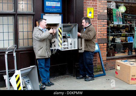 Männer arbeiten an einem Hole-in-Automaten Stockfoto