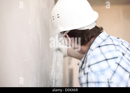 Arbeiter richtet Wand für die Leitung Stockfoto