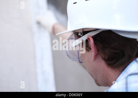 Arbeiter richtet Wand für die Leitung Stockfoto