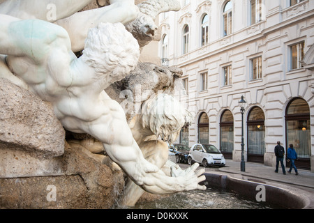 Marmorskulptur eines Mannes in den Brunnen außerhalb der Hofburg streckt Arm, Straße mit Autos und Fußgänger. Stockfoto