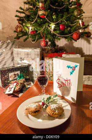 MINCE PIES, SHERRY UND KARTE FÜR SANTA/WEIHNACHTSMANN MIT GESCHMÜCKTER WEIHNACHTSBAUM UND GESCHENKE/GESCHENKE Stockfoto