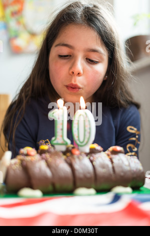 Mädchen bläst Geburtstagskerzen Stockfoto