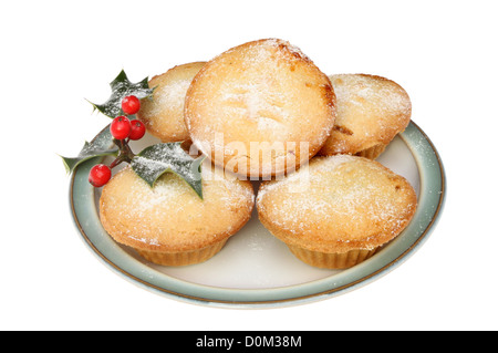 Mince Pies auf einem Teller mit Puderzucker bestäubt und dekoriert mit Holly isoliert gegen weiß Stockfoto