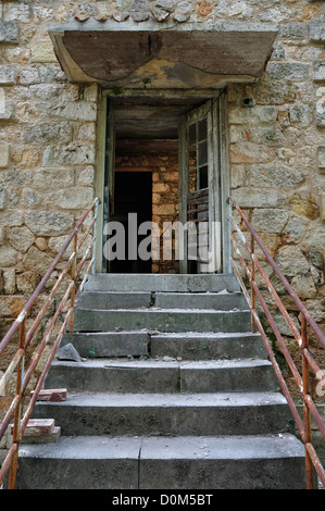 Defekte Tür und bröckelnden Treppe. Verlassene Gebäude außen. Stockfoto
