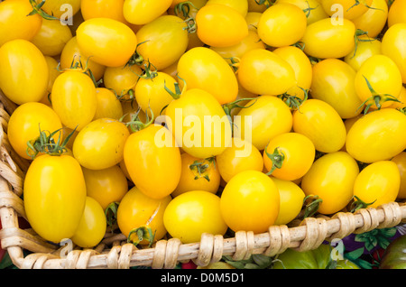 Gelbe Cherry-Tomaten auf dem Display in Weidenkorb auf dem Markt Stockfoto