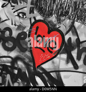 Rot lackierte Liebe Herz auf Graffiti bedeckt schwarze und weiße Wand Hintergrund. Selektive Sättigung. Stockfoto