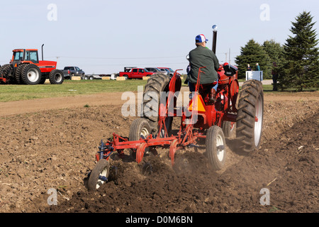 1950 in der Nähe von Farmall, Modell M, Pflügen ein Feld mit einem 3-unten Pflug auf einem Bauernhof Hebron, Illinois. Stockfoto