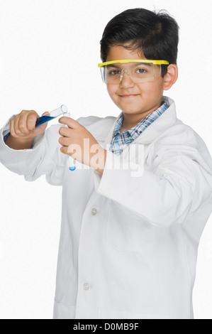 Junge in einem Laborkittel experimentieren mit Reagenzgläsern Stockfoto