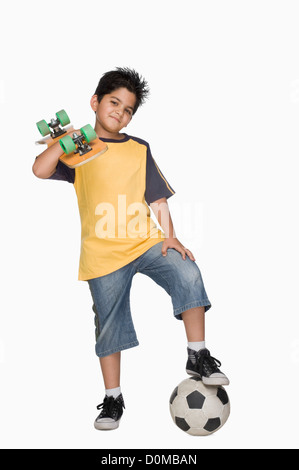 Junge mit einem Skateboard und einem Fußball Stockfoto