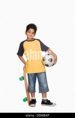 Junge mit einem Skateboard und einem Fußball Stockfoto