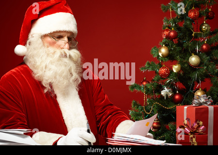 Porträt von Santa Claus Blick auf Umschlag in seinen Händen Stockfoto