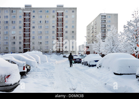 Panel-Gebäude und Schnee bedeckten Parkplatz in der Stadt mit walker Stockfoto