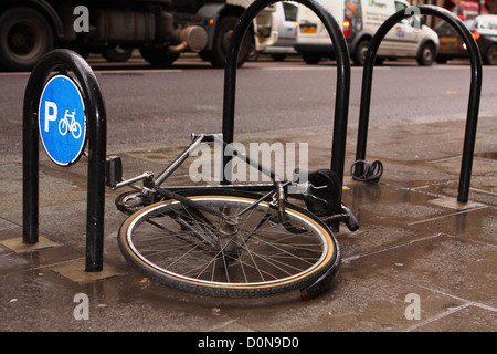 Ein geschändeter Fahrrad noch angekettet an einem Zyklus Gestell in London Stockfoto
