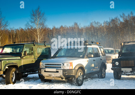 Land Rover Discovery und zwei Verteidiger. Drei SUV auf Hintergrund der russische Winter. Stockfoto