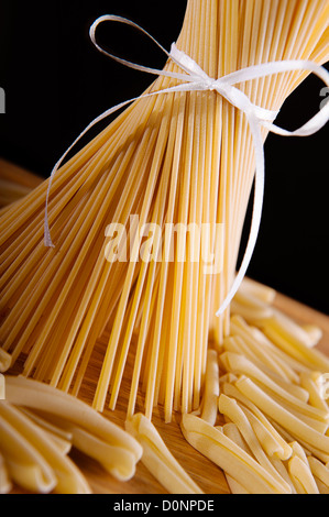 Eine Reihe von langen Spaghetti Nudeln auf dunklem Hintergrund Stockfoto