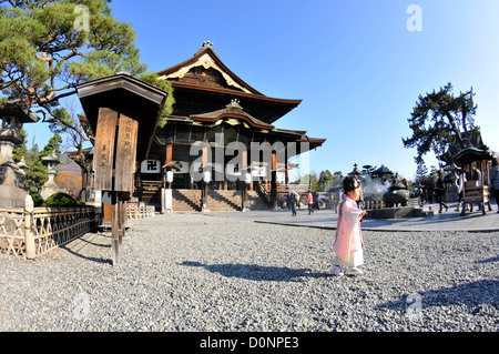 Junge Mädchen geht vor der Haupthalle, Hondo, Zenkoji Tempel, Nagano, Japan Stockfoto