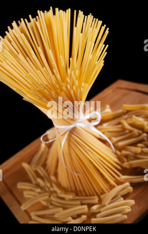 Eine Reihe von langen Spaghetti Nudeln auf dunklem Hintergrund Stockfoto