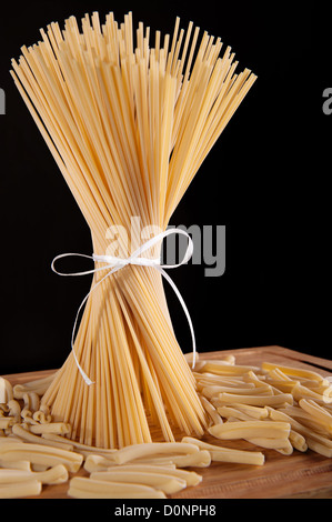 Band gebunden Haufen Spaghetti Nudeln auf schwarzem Hintergrund Stockfoto