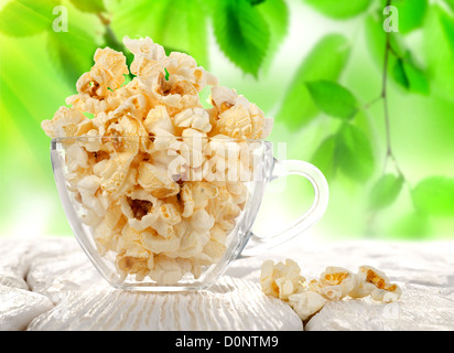 Popcorn in einer Schale auf einem Hintergrund von Laub Stockfoto