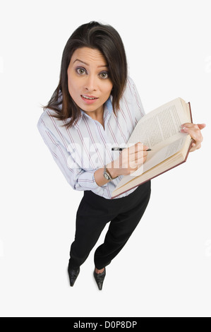 Porträt einer Geschäftsfrau, die Markierung auf ein Buch Stockfoto