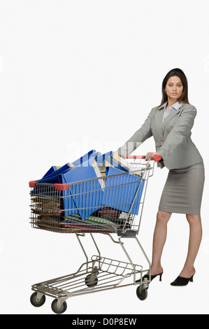 Geschäftsfrau schieben eines Einkaufswagens gefüllt mit Dateien Stockfoto