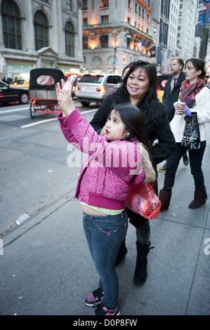 Hispanischen Mädchen trägt Lippenstift fotografiert auf der Fifth Avenue in Manhattan während der Thanksgiving-Wochenende, 2012. Stockfoto